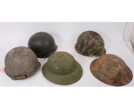 Group of various military helmets to include American Army M1917 steel helmet, two Second World War American M1 steel helmet,