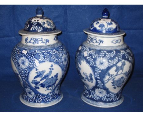 Pair of modern blue and white Chinese porcelain baluster shaped jars and covers with reserved figural and foliage panels.  Se