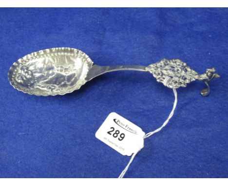 Large Dutch caddy type, repousse decorated silver spoon with figural decoration. CONDITION REPORT: Damage/split to top of han