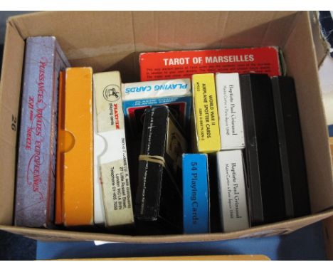 A box of assorted playing cards, tarot cards and other similar.