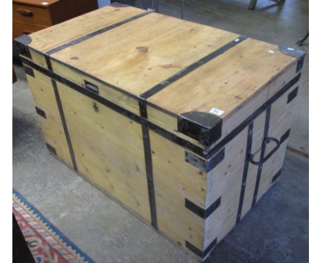 Large vintage pine trunk with carrying handle and metal banding.