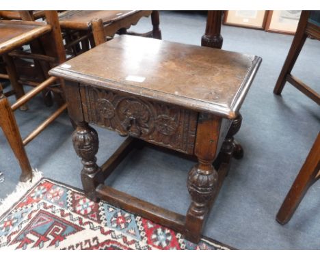 AN OAK JOINT STOOL WITH CARVED 'CUP AND COVER' LEGS, fitted a frieze drawer carved with a 'Romayne' head