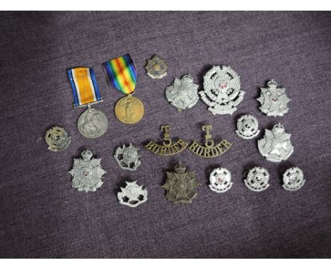 A collection of Border Regiment Cap Badges, Helmet Badge, Badges and Brooches and a pair of WW1 Medals, WW1 medals Victory &a