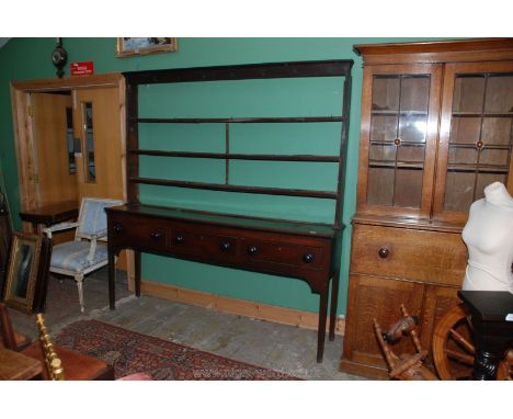 An early 19th c. Oak Welsh Dresser with three shelf rack having iron cup hooks, three drawers to the single plank top base, s