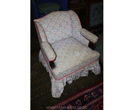 A low Victorian upholstered Nursing Chair in toad and toadstool print fabric, with turned arm supports and turned legs.