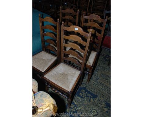 A contemporary set of four Oak ladder back Dining Chairs having five shaped bars to the backs, rush seats and on turned front