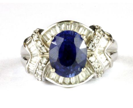 An 18ct white gold sapphire and baguette cut diamond set ring, (O).