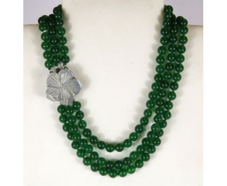 A lovely three row necklace of 8mm apple green jade beads on a mother of pearl clasp.