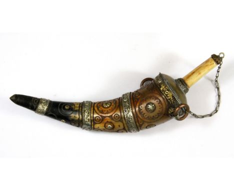 A Tibetan horn and white metal overlaid powder flask, H. 25cm. (Prov. Samy collection).