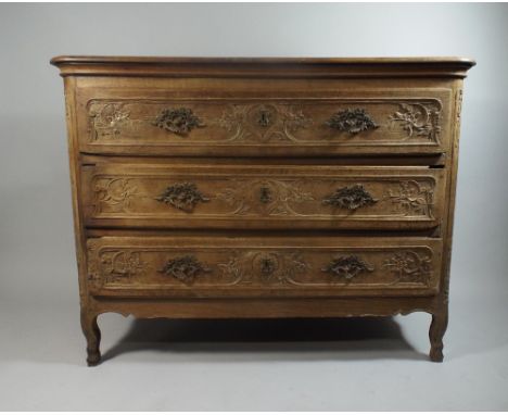 An 18th Century French Oak Commode Chest with a Three Plank Top Over Three Drawers with Carved Rococo Decoration and Brass Ha