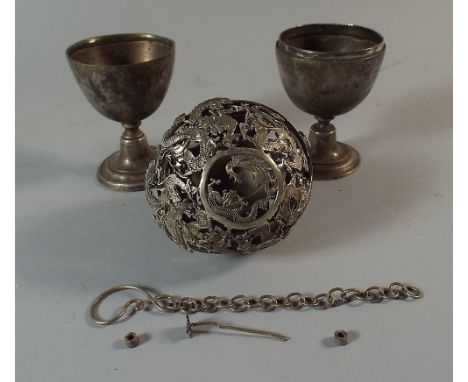 An Oriental White Metal Pierced and Gimballed Travelling Compass Holder and A Two Section Ovoid Double Egg Cup.
