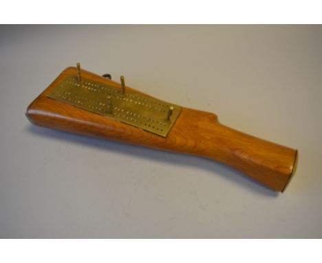 A Brass Mounted Novelty Cribbage Board in the Form of a Rifle Stock and the Four Pegs in the Form of Miniature Bullets. 34cms