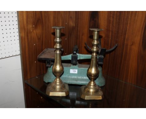 A PAIR OF BRASS CANDLESTICKS AND A SET OF VINTAGE SCALES