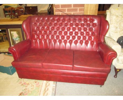 AN OXBLOOD BUTTON BACK 3 SEATER SOFA