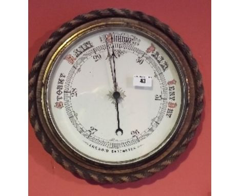 An Early 20th Century Circular Aneroid Barometer in a carved oak rope-twist frame. 34.5cm diameter.