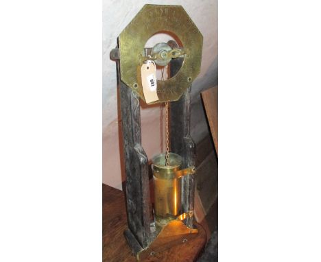 A 19th Century Water Clock, with carved wooden frame, engraved brass dial with Roman numerals, plate to base with engraved sc