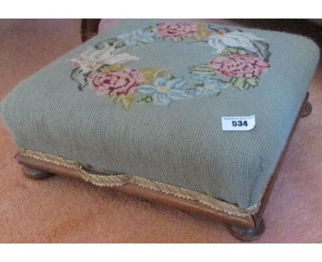 A 19th Century Mahogany Framed Footstool, the square top with floral wreath tapestry cover, on four bun feet.