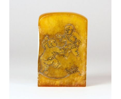 An early 20th century Chinese yellow soapstone seal decorated with boys playing and a stem of flowers, H. 5.5cm.