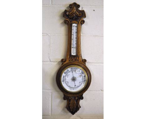 A carved oak barometer and thermometer, L. 88cm.