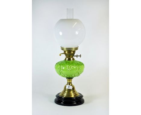 A 19th century oil lamp with a moulded green ceramic well and a brass base, H.56cm.