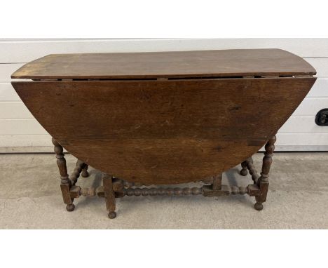 A vintage dark oak drop leaf, gate leg table with turned and bobbin design to legs and stretchers. Fully extended approx. 72 