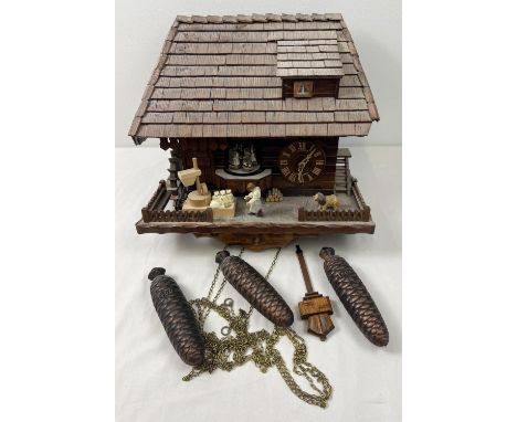 A wooden chalet style flour mill Cuckoo clock with pine cone weights by Schneider. Musical movement to inside that plays "Ede