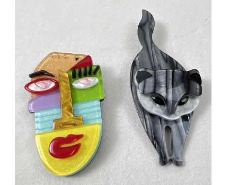 2 Lea Stein style acrylic brooches. A silver/grey coloured cat brooch and a multi coloured abstract design face brooch. Large