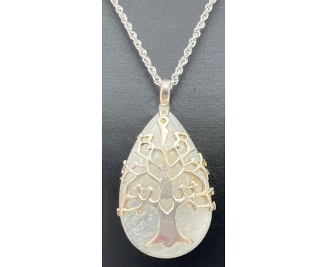 A modern design teardrop shaped moonstone pendant with Tree Of Life  design silver overlay. On a 20" rope chain with spring r