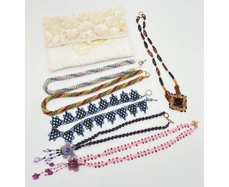 A cream satin beaded jewellery roll with 6 handmade faux pearl and glass bead necklaces. In various colour ways and designs. 