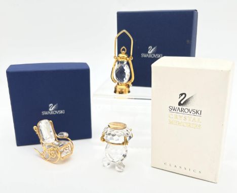 3 boxed small Swarovski crystal and gold tone metal collectibles. Comprising a Tilley lamp, rocking chair and a oil lamp.  La