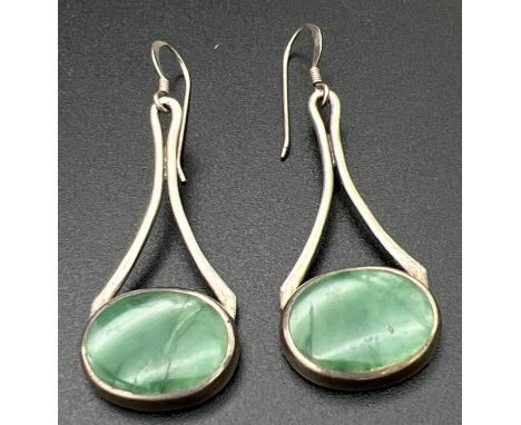 A pair of modern design silver drop earrings set with natural green stones. Silver marks to back of earrings and to posts. To