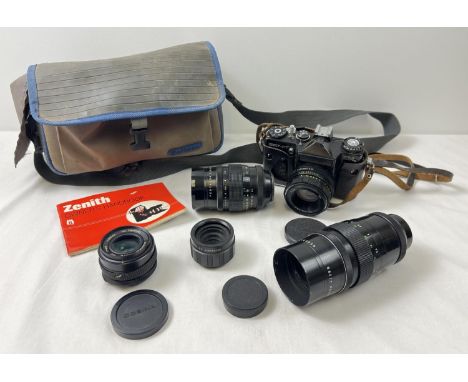 A vintage Zenit EM Camera with a collection of lenses, carry bag and handbook. Lenses comprise: Pentacon 4/200, Pentacon 2.8/