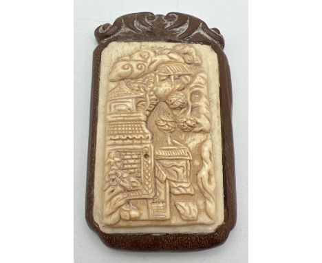 A Chinese carved bone panel set into a decorative wooden mount. With small signed disc mounted to reverse. Approx. 7cm x 4.25