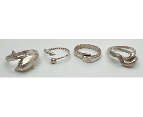 4 silver and white metal rings. To include wrap around dolphin ring and modern contemporary design. Ring sizes M, O and S. 