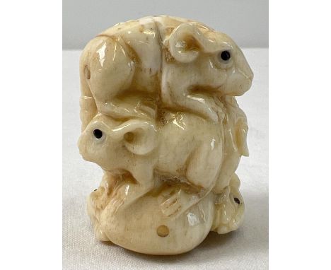 A small carved netsuke modelled as a stack of mice with polished finish and signature to underside. Approx. 4cm long. 