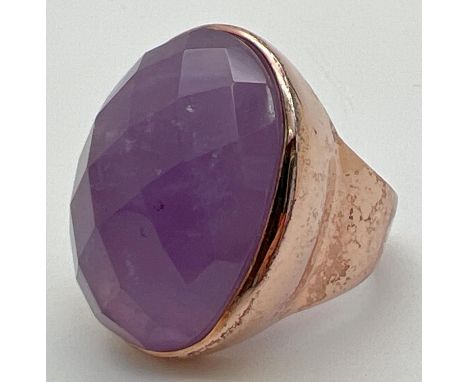 A silver cocktail statement ring in rose gold finish, set with a large oval checker board cut amethyst. Silver mark to inside