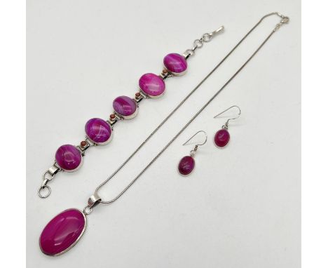 A matching set of silver and pink dyed agate jewellery. A pair of oval drop earrings, an oval panel bracelet also set with sm