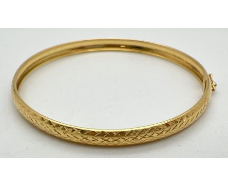 A modern silver gilt bangle with engraved diamond pattern throughout. With push clasp and safety clip. 925 marked to inside o