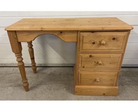 A modern pine 3 drawer dressing table with turned legs and bun drawer handles. Approx. 66 x 106 x 41.5cm. 