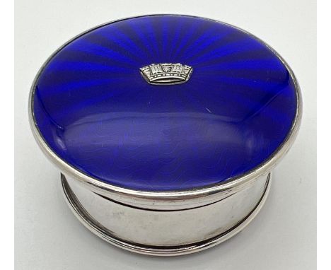 An Art Deco silver jewellery/trinket box with royal blue guilloche lid with central crown shaped embossed detail. Raised on 3