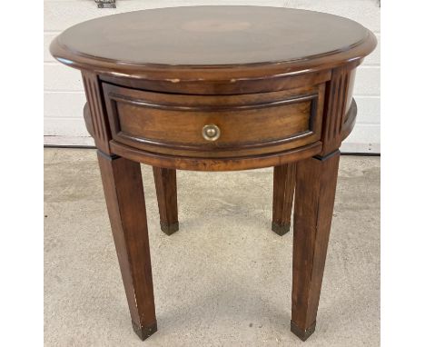 A modern circular shaped drum table raised on 4 squared shaped tapered legs and with central draw. Inlaid detail to top. Appr