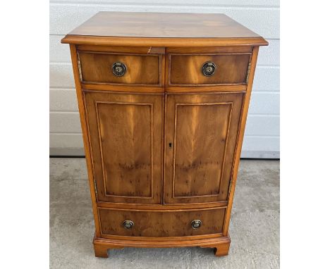 A Bevan Funnel 'Reprodux' yew wood veneer bow fronted cabinet with brass ring handles. 2 door cupboard with interior shelf an