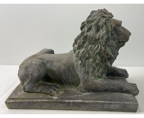 A large stoneware figure of a seated lion on a rectangular tile base, with a bronzed effect painted finish. Approx. 26cm tall