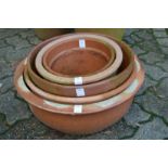 A collection of terracotta circular planters.