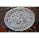 A classical style oval wall plaque moulded with cherubs and a lion.