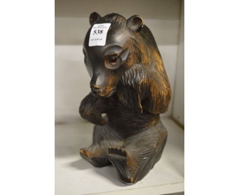 A black forest style carved wood seated bear.