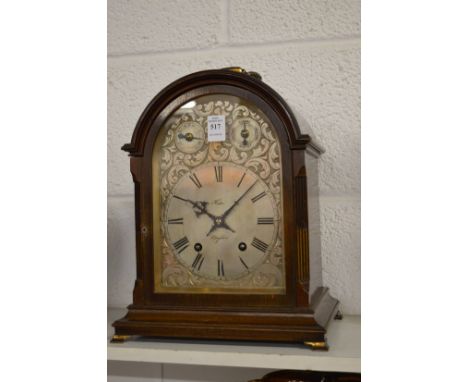 A mahogany cased mantle clock with engraved silvered dial.