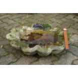 A reconstituted stone shell shaped bird bath top.