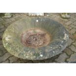 A large circular reconstituted stone garden planter (lacking base).