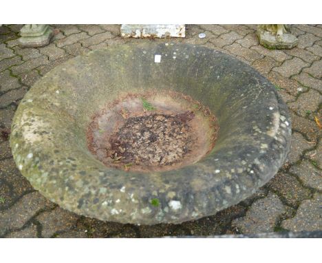 A large circular reconstituted stone garden planter (lacking base).